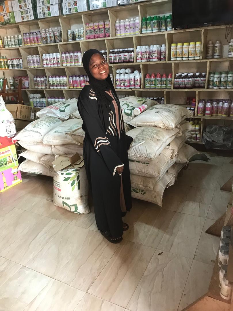 Staff member beside stacked fertilizer bags